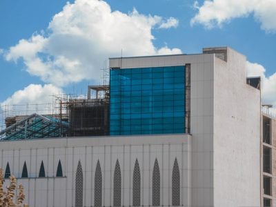 pexels-photo-18197166-18197166 A contemporary building exterior with blue glass facade against a cloudy sky.