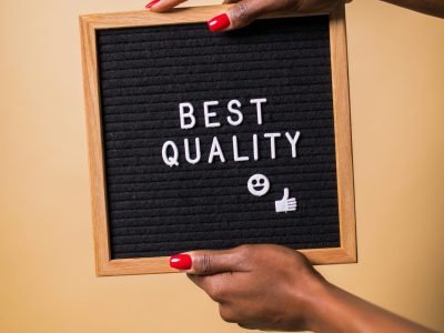 pexels-photo-7564203-7564203-1 Hands holding a letter board with 'Best Quality' text, emoji, and thumbs up.